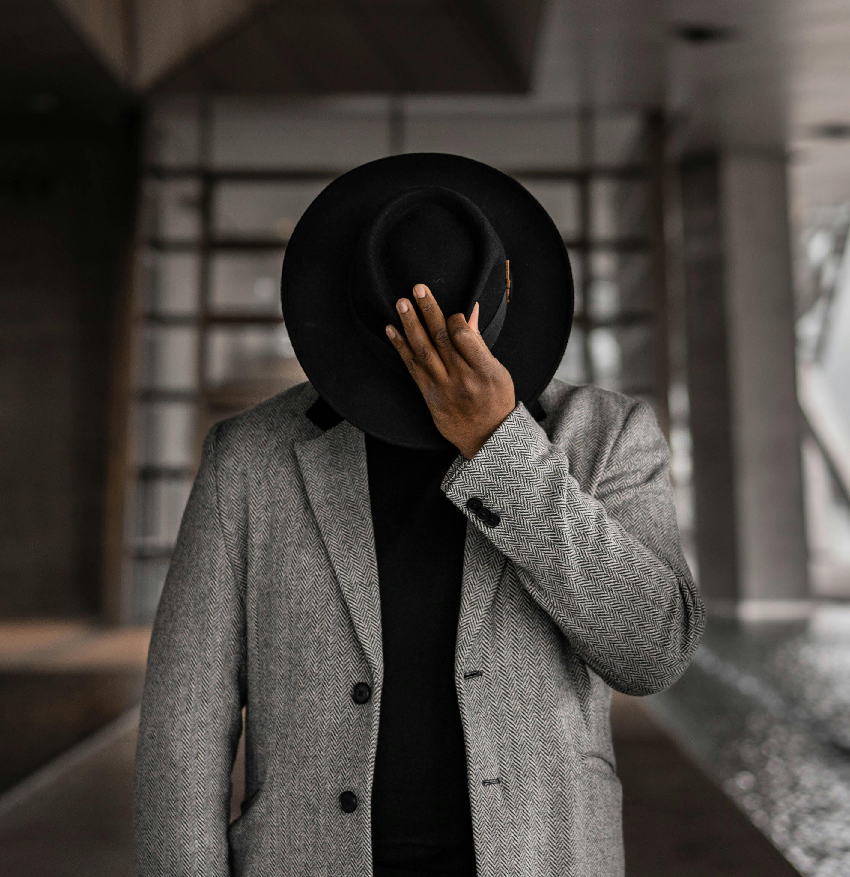 Black man in trench coat and black cap